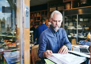 Homem sentado lendo documentos