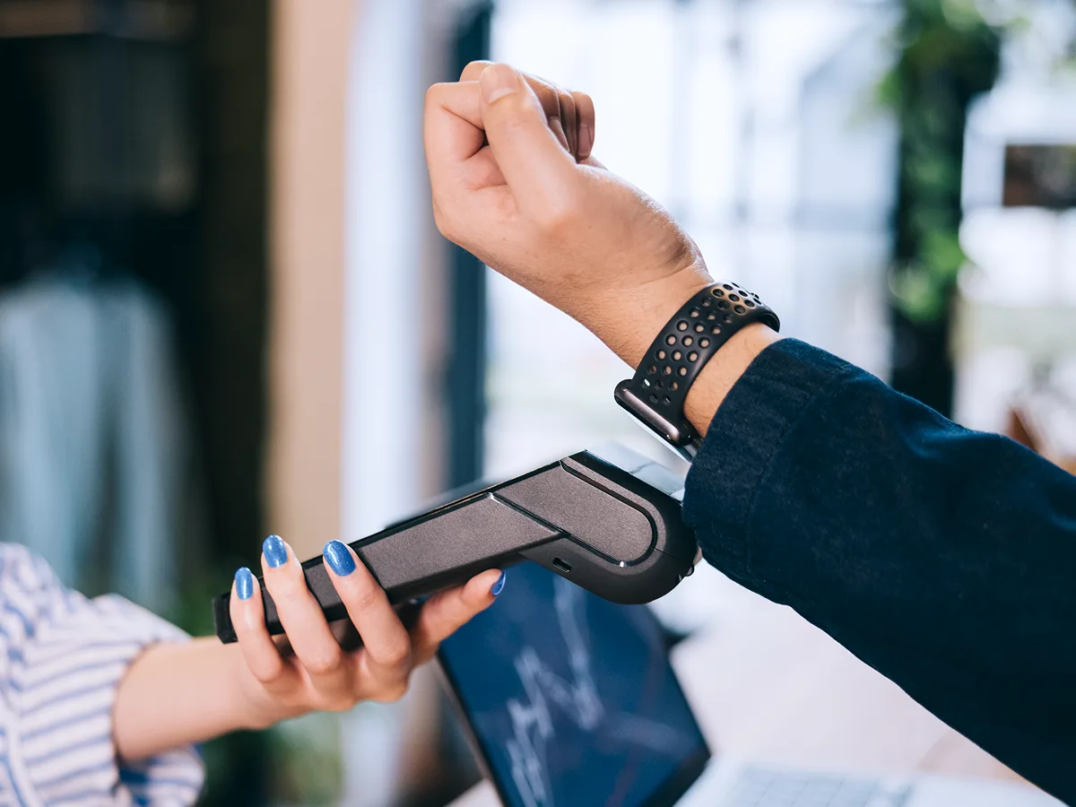 Pagamento por aproximação usando smartwatch integrado à carteira digital PJ, mostrando praticidade para empresas.