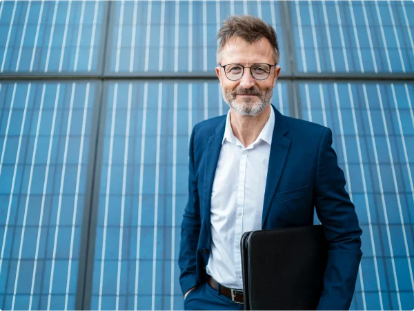 Homem de social em frente a um painel solar.