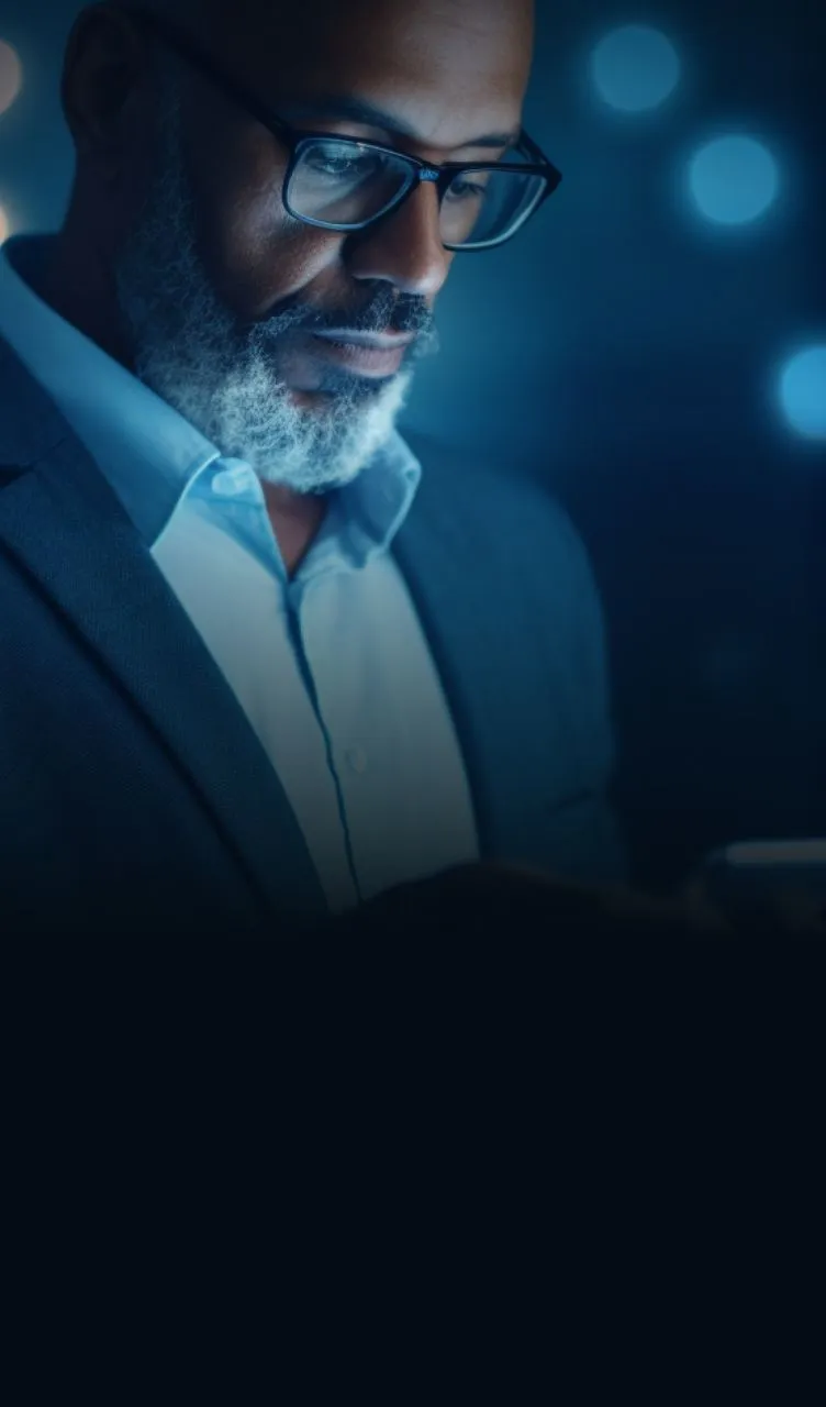 Homem de negócios usando um smartphone para gerenciar operações de câmbio empresarial online, refletindo a segurança e a confiabilidade dos serviços de câmbio para empresas oferecidos pelo BTG Pactual.