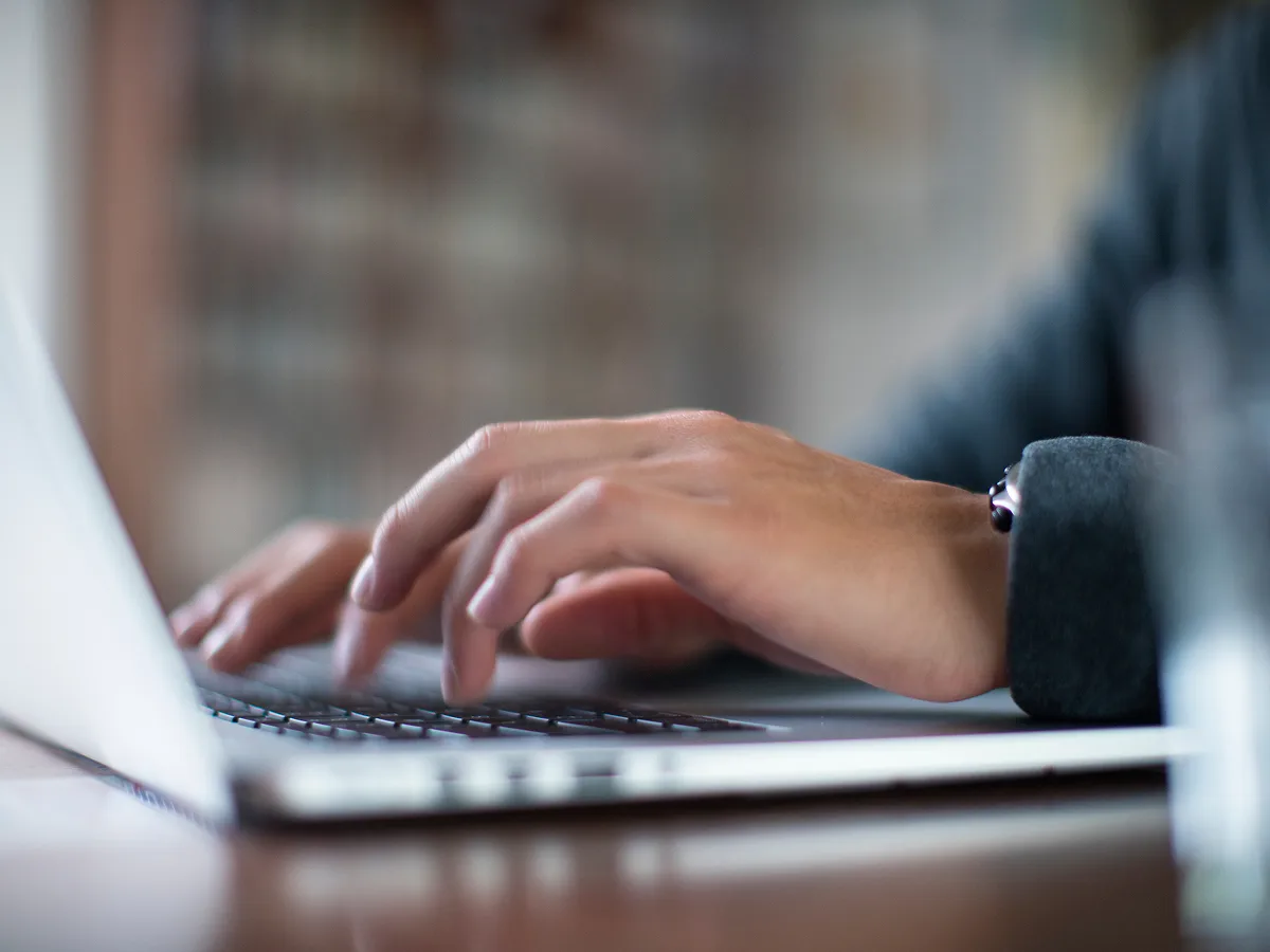 mãos de um executivo digitando em um notebook