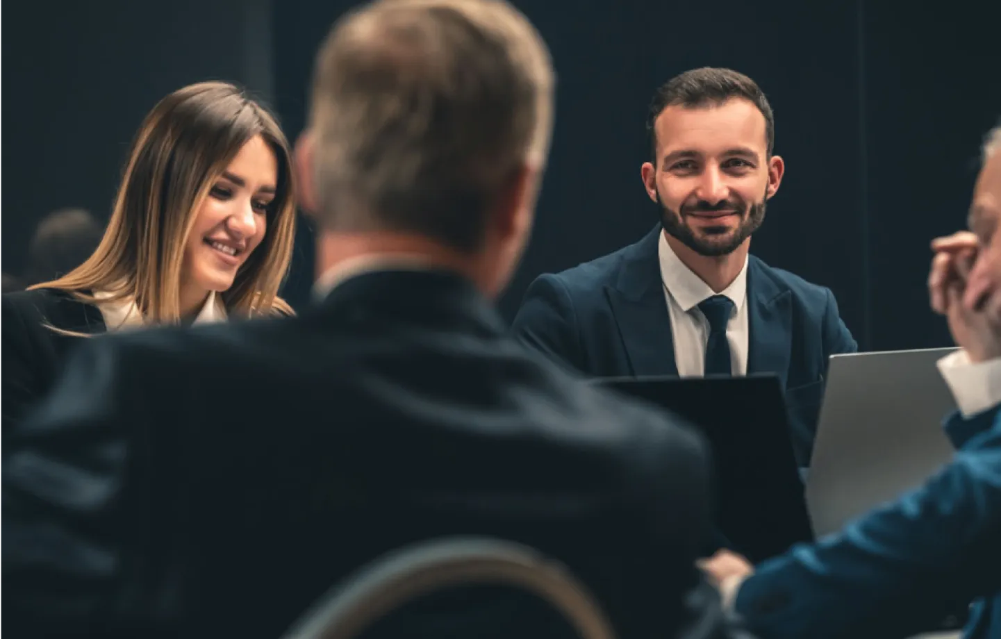 Pessoas em sala de reunião, conversando e colaborando,representando parcerias e trabalho em equipe