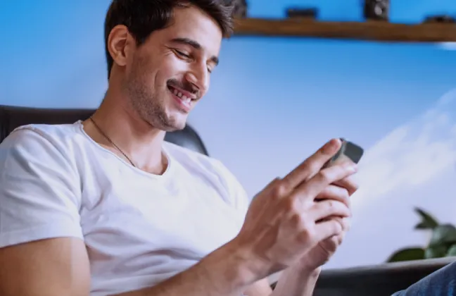 Um empresário segurando um celular, transmitindo a ideia de segurança e proteção que um seguro empresarial pode proporcionar ao negócio.