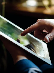 Foco em um tablet com a função touch sendo utilizada