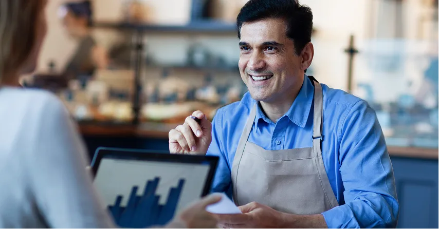 empreendedor conversando com gerente de banco e analisando um gráfico