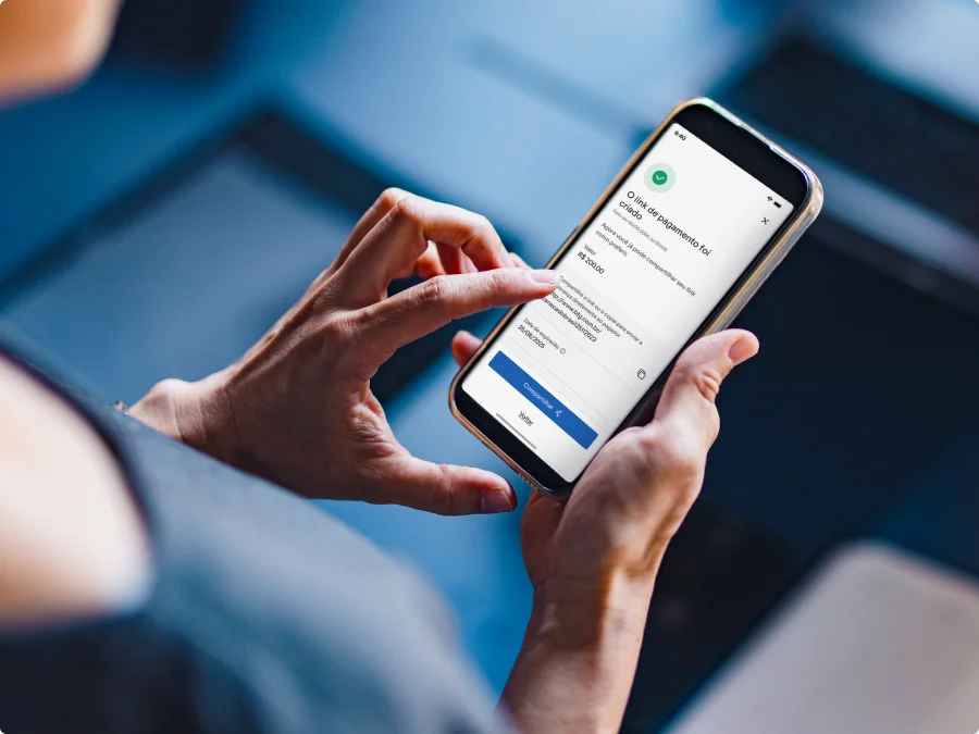 Mão segurando celular com interface de pagamentos digitais BTG Pay.