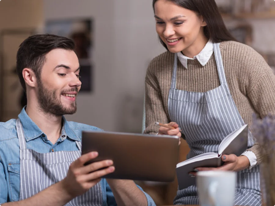Pessoas utilizando notebook para acessar soluções BTG Pay em ambiente corporativo.