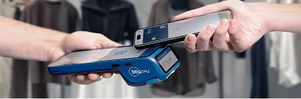Transação sendo realizada com a maquininha do BTG Pay e um celular com sistema de aproximação