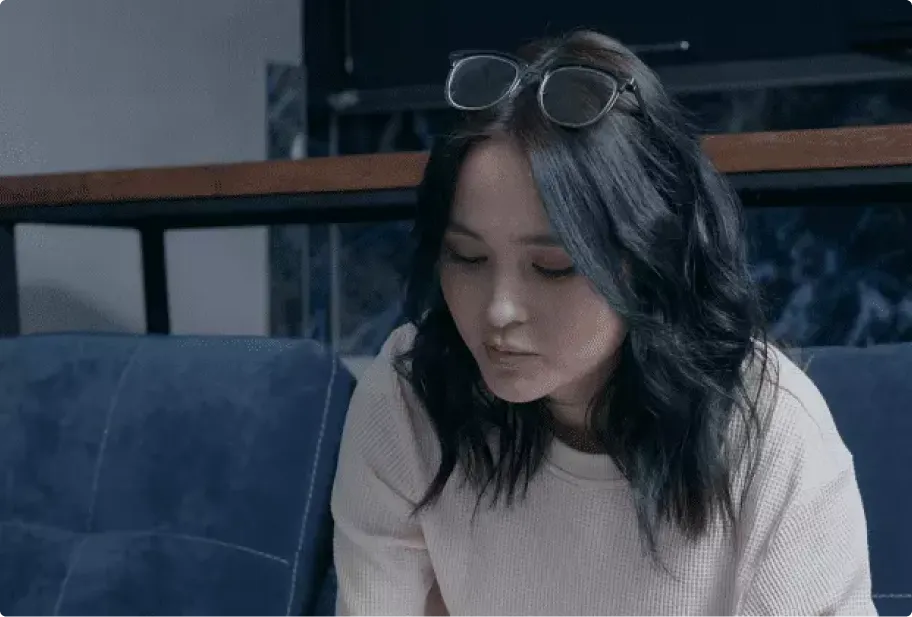 Mulher com óculos na cabeça sentada em sofá